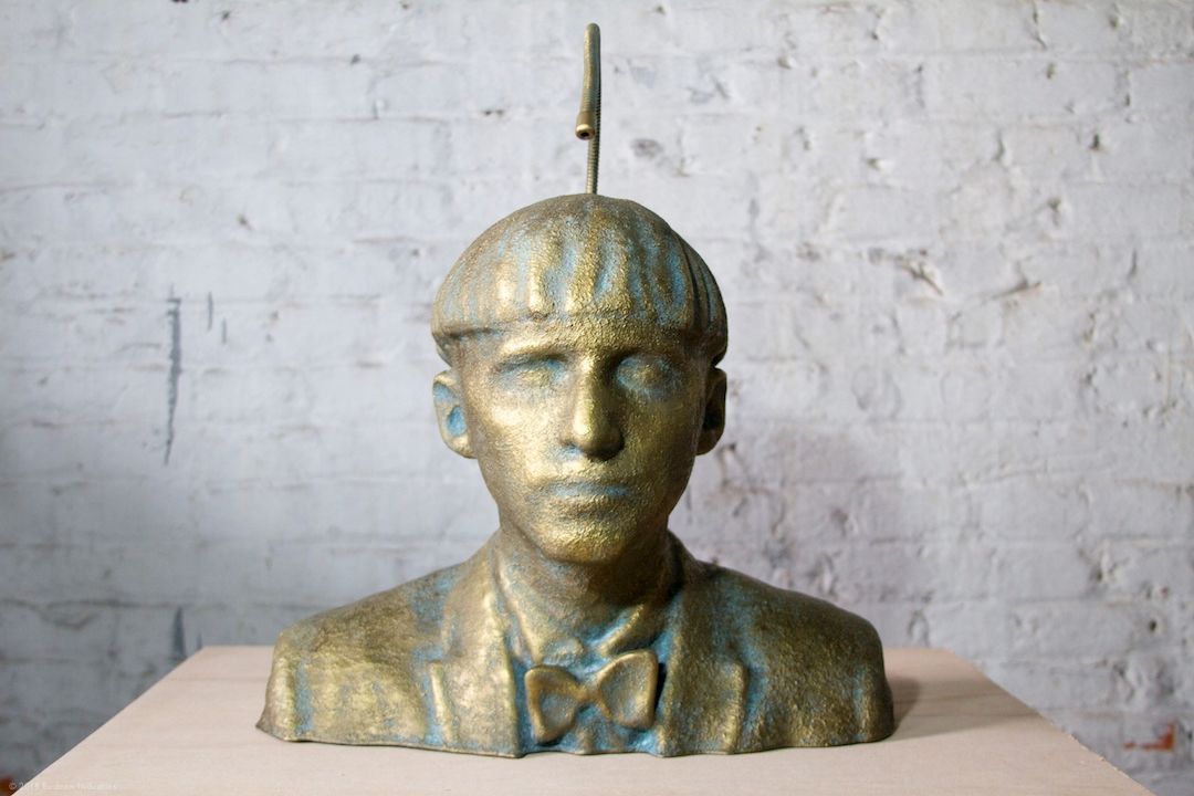 A gold-leafed sculpture of Neil Harbisson with an antenna extending from the head
