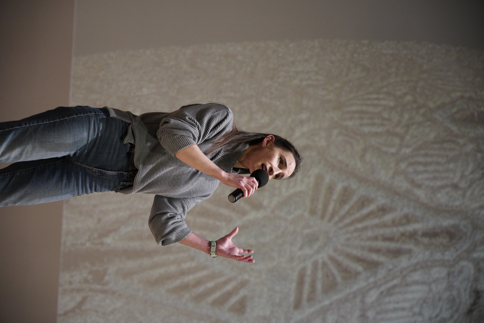 Stephanie speaking with the Scarab Vase pattern projected behind her